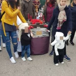 Madres y niños llevando paso de Semana Santa en centro infantil Goofy