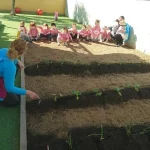 niños y profesoras en el huerto de la escuela en centro infantil Goofy