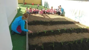 niños y profesoras en el huerto de la escuela en centro infantil Goofy